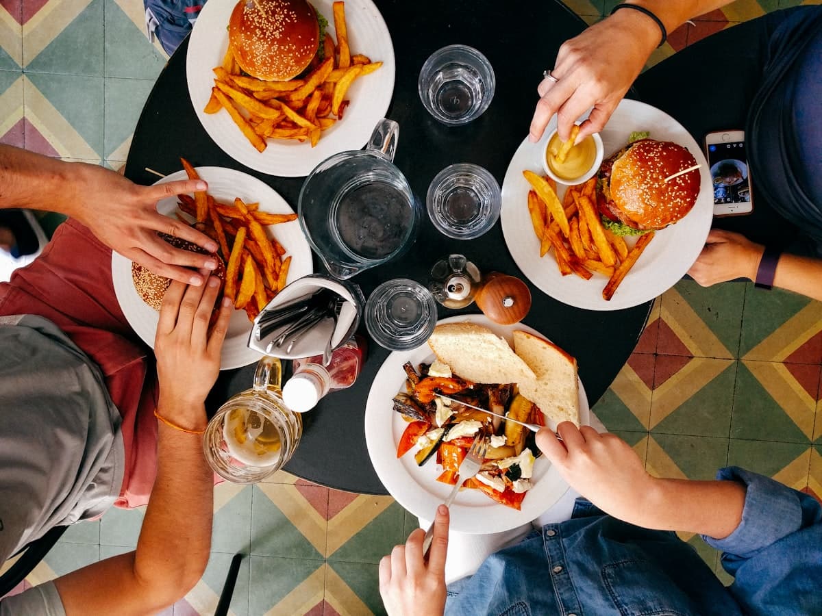 Friends enjoying cheesesteaks and fries